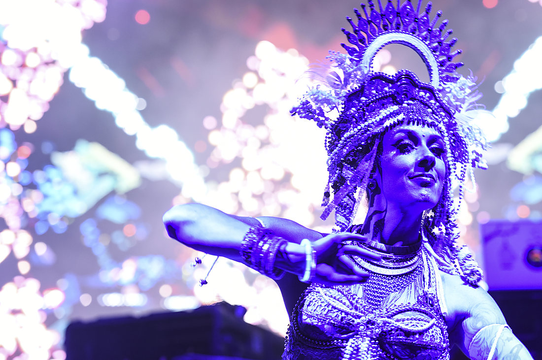 Performer in costume lit by stage projection